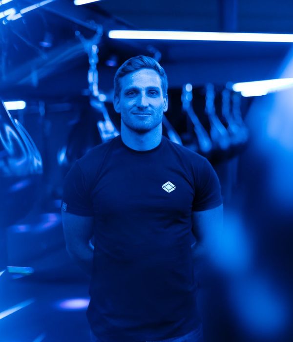 Man performing a strength training exercise in a modern gym environment.